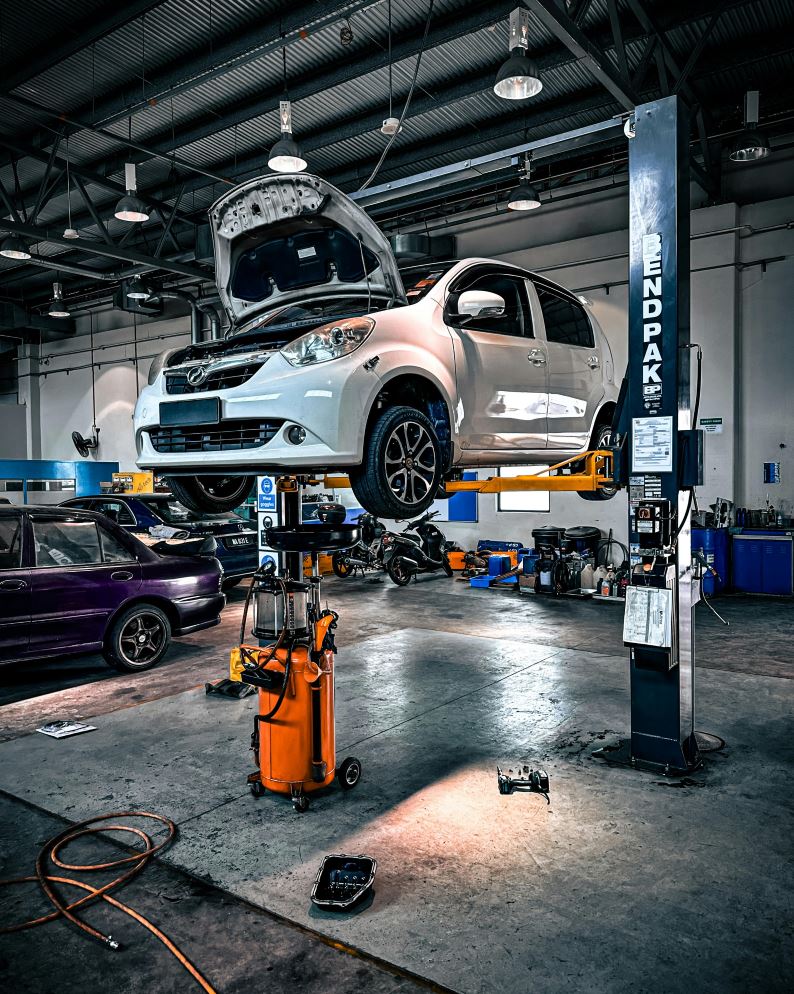 A mechanic changing car engine oil in a workshop